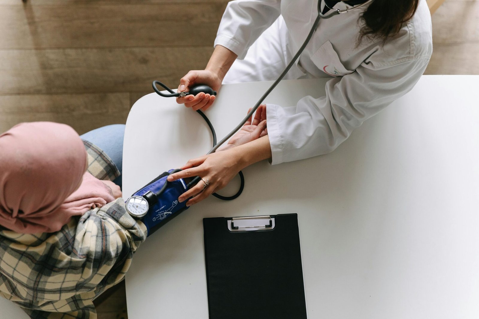 A medical practitioner checks a patient's blood pressure in a clinical setting, showcasing healthcare service.